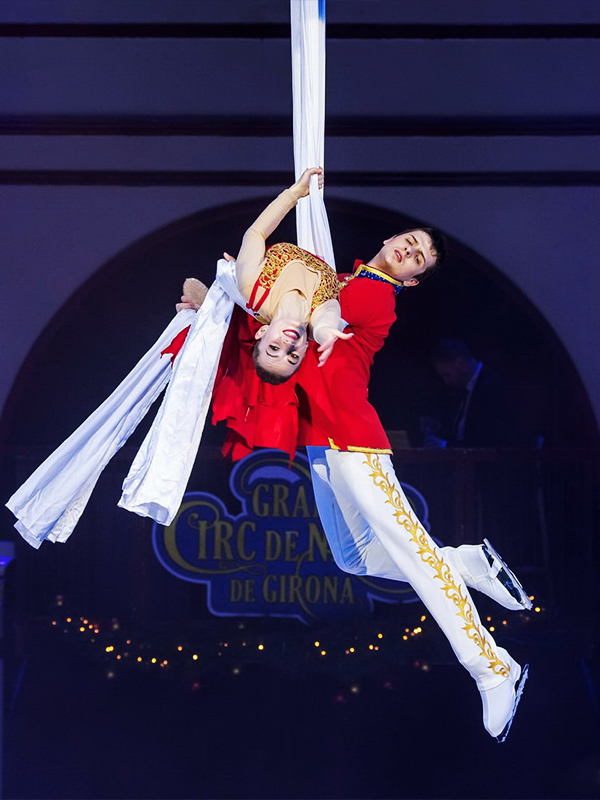 Nutcracker prince holding Marie on aerial silks. The Nutcracker by Moscow circus on ice