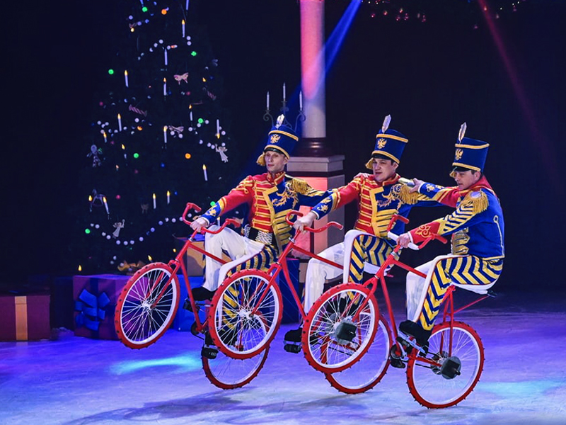 Hussars riding bicycles on rear wheel. The Nutcracker by Moscow circus on ice