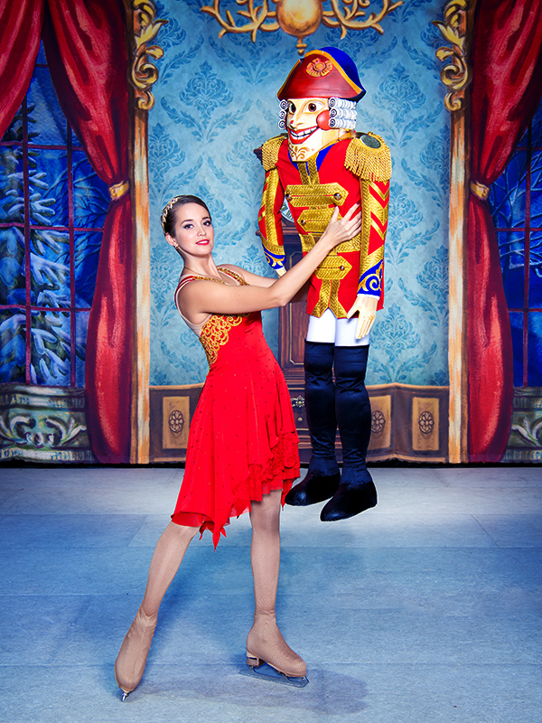 Marie wearing red dress is holding a nutcracker doll. The Nutcracker by Moscow circus on ice